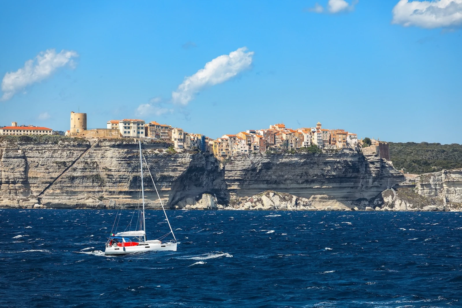 Bateau naviguant au pied des falaises de Bonifacio
