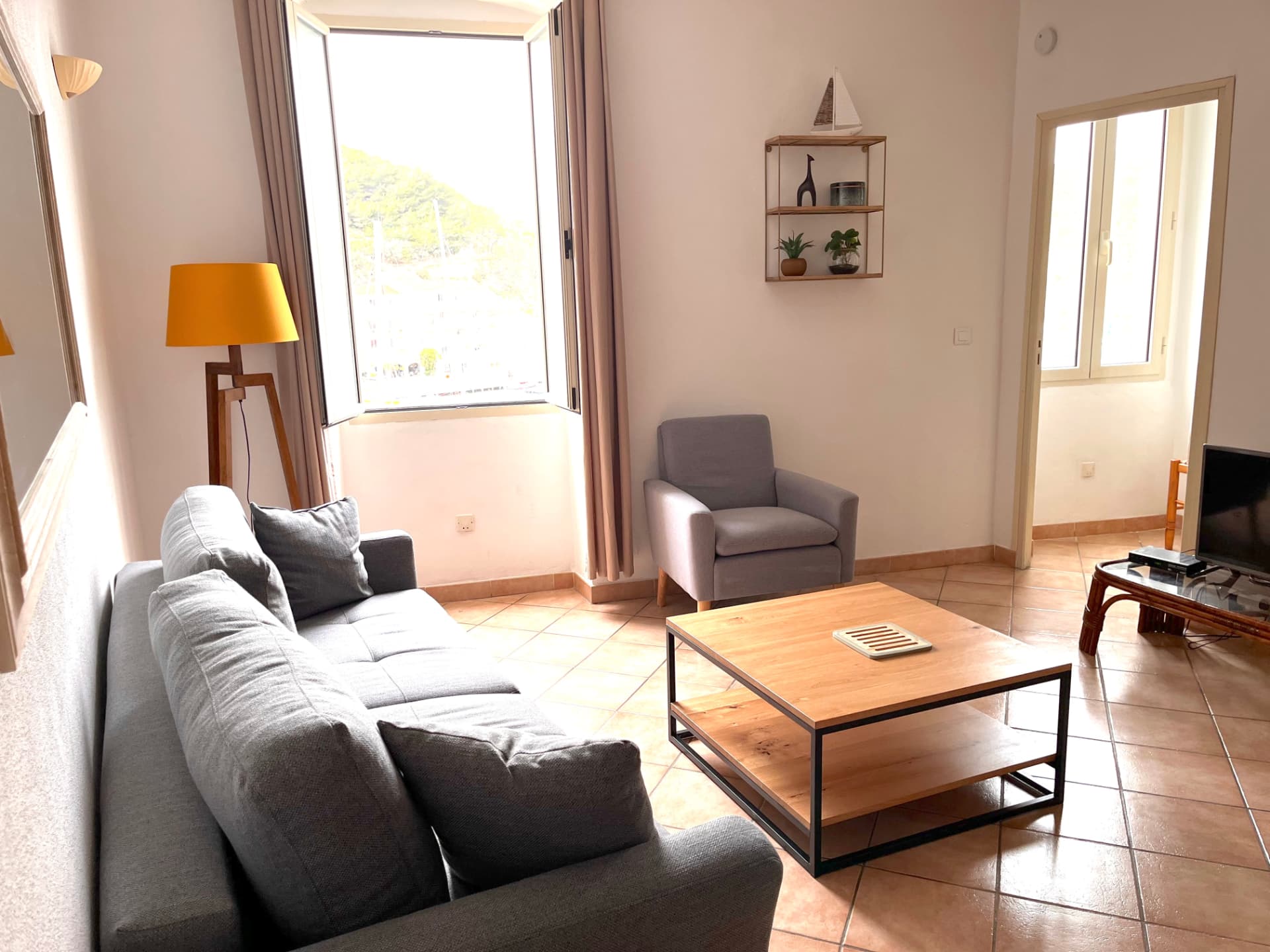 Coin salon de Calacuccia avec fauteuil et fenêtre ouverte